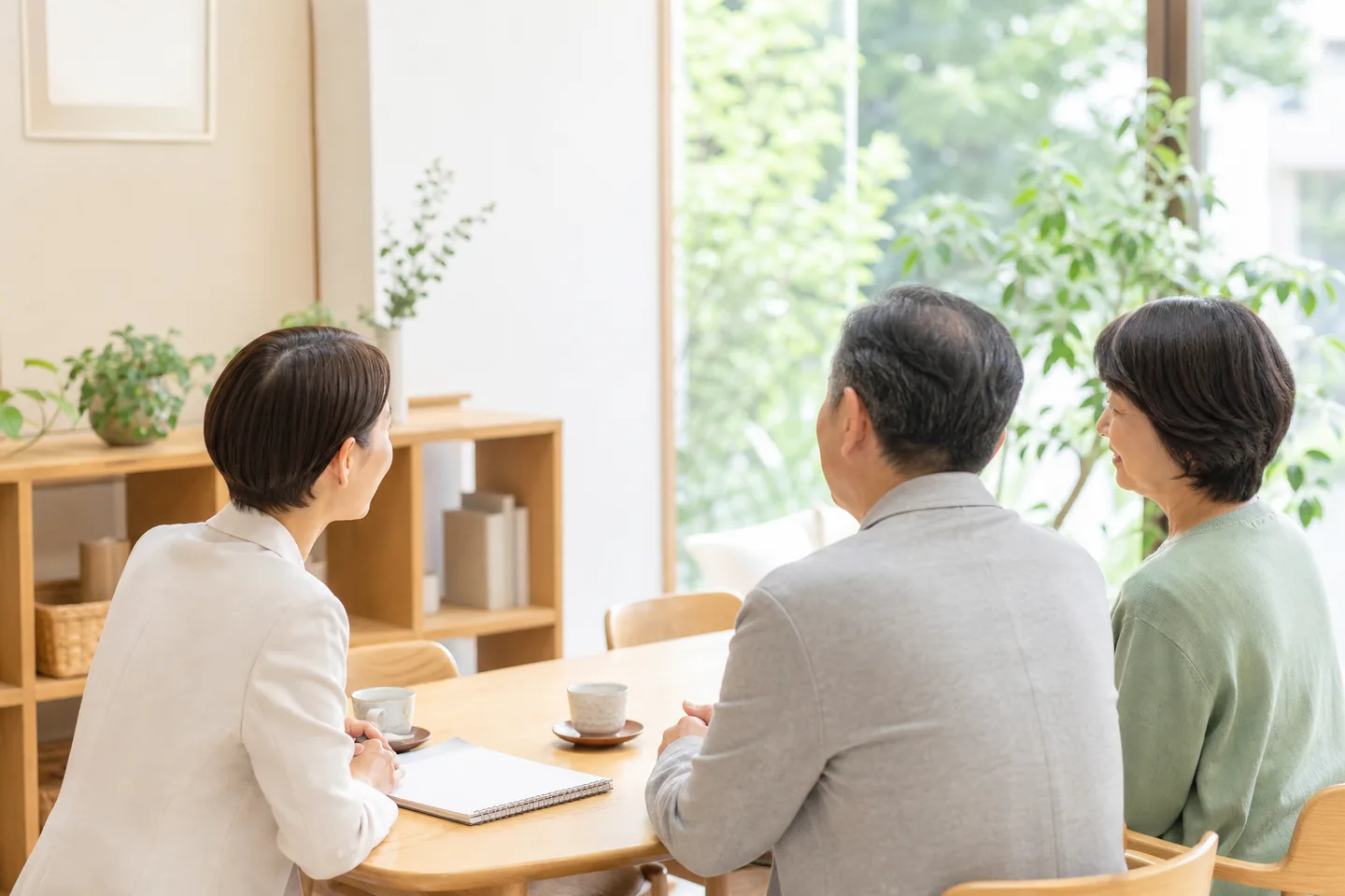 明るい相談室で高齢の方とご家族が支援者に相談している様子